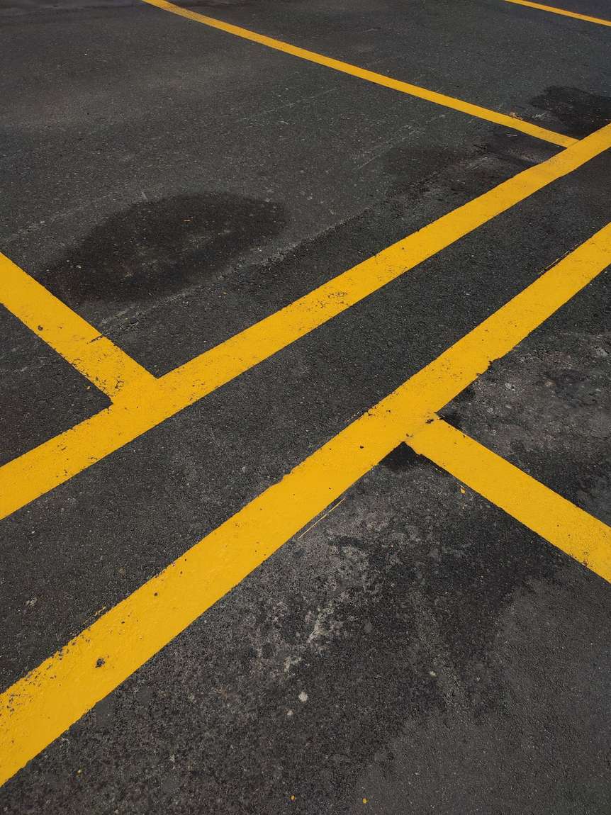 Bright yellow parking lines on dark asphalt